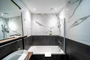 łazienka z wanną, toaletą i umywalką w obiekcie Hotel Nes Amsterdam w Amsterdamie
