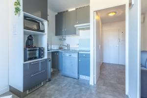 a kitchen with blue cabinets and a sink at La Baie des Anges in La Ciotat