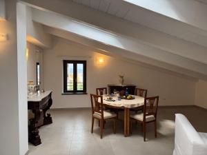 a dining room with a table and chairs and a piano at Sea View Loft Meta Sorrento Coast Free Parking in Meta