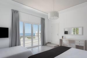 a bedroom with a bed and a desk with a view of the ocean at Villa Cosambeli in Paramonas +57 photos