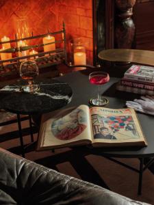 a book on a table with two glasses of wine at The Benjamin House in Rīga