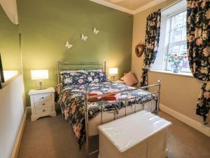 ein kleines Schlafzimmer mit einem Bett und einem Fenster in der Unterkunft Stylish & Contemporary 5 * Fully Renovated Luxurious Holiday Cottage Ambleside in Ambleside