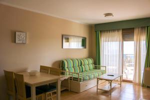 a living room with a chair and a table at Apartamentos Esmeralda Suites Unitursa in Calpe