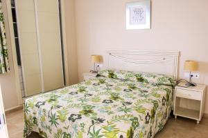 a bedroom with a bed with a floral bedspread at Apartamentos Esmeralda Suites Unitursa in Calpe +72 photos