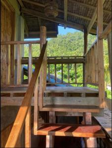 a wooden staircase in a building with a porch at Red Gumamela House in San Isidro +22 photos