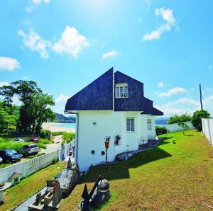 a small white house with a black roof at Comfortable house with sea view in Viveiro, 200 m² in Viveiro