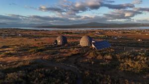 a field with two tents and a solar panel at Dome with Epic Fjord Views in Puerto Natales