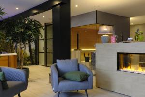 a living room with a blue chair and a fireplace at Bed & Wellness De Leilinde in Nieuwe-Niedorp