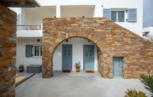 an archway in a brick building with two blue doors at Nefeli in Livadi