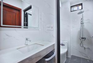 a white bathroom with a sink and a toilet at An'Home Apartment Westlake in Hanoi +71 photos