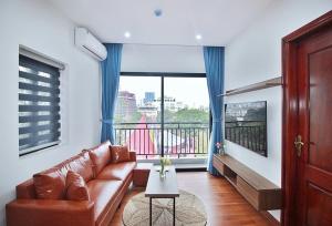 a living room with a couch and a large window at An'Home Apartment Westlake in Hanoi
