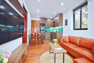 a living room with a couch and a kitchen at An'Home Apartment Westlake in Hanoi