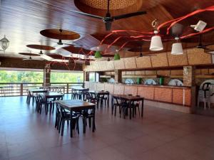 una sala da pranzo con tavoli e sedie in un ristorante di Cockatoo Pool & Beachfront Transient Your Relaxing Family Getaway by the Sea a Città di Puerto Princesa