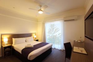 a hotel room with a bed and a window at Cottesloe Beach Hotel in Perth