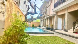 a swimming pool in the courtyard of a building at Semilang House in Ngurah Rai International Airport