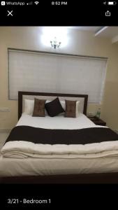 a bedroom with a large bed with pillows on it at Family Friendly Guest House in Bengaluru