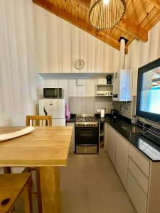 cocina con fogones y mesa con ordenador en Monoambiente 203B - Excelente ubicacion, en San Martín de los Andes