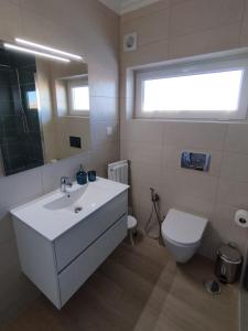 a bathroom with a white sink and a toilet at Casa dos Búzios - 1-bedroom apartment with sea view in Armação de Pêra +15 photos