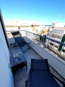 a balcony with a table and chairs on a building at Casa dos Búzios - 1-bedroom apartment with sea view in Armação de Pêra