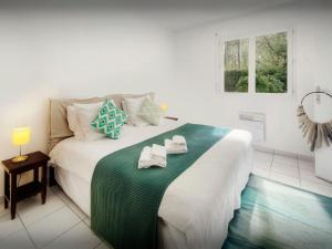a bedroom with a large bed with towels on it at Villa Samasti - OVO Network in Lacanau
