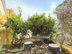 a table and chairs in a garden with trees at 250 mt dal mare - Relax e Posto Auto in Pietra Ligure
