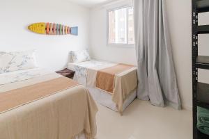 En eller flere senge i et værelse på Varanda Rede Vista Mar 8 Andar • Ed Palmer • NOMDS