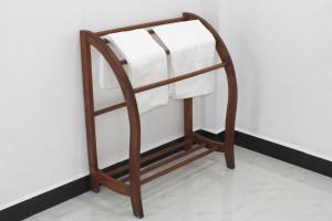 a towel rack with white towels on a wall at Royal Breeze Resort Sigiriya in Sigiriya