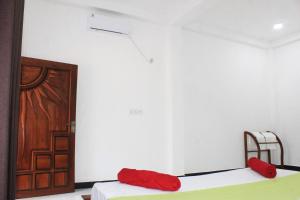 a room with two beds and a door at Royal Breeze Resort Sigiriya in Sigiriya