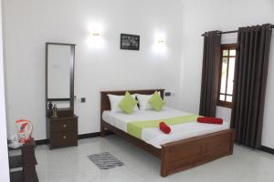 a bedroom with a bed and a mirror at Royal Breeze Resort Sigiriya in Sigiriya