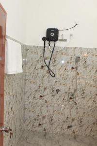 a bathroom with a shower with a camera on the wall at Royal Breeze Resort Sigiriya in Sigiriya