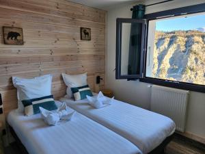 two beds in a room with a window at Chalet Sainte Anne in Condamine-Châtelard