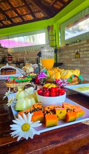 un tavolo con diversi tipi di cibo su di esso di Villa das Águas a Monte Alegre do Sul
