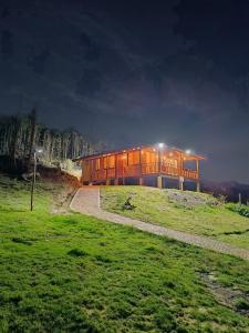 a building on top of a hill at night at Cabaña Loto - Paipa in Paipa