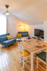 ein Wohnzimmer mit Tisch und Couch in der Unterkunft Au cœur de la ville, traversant et tout confort in Vannes