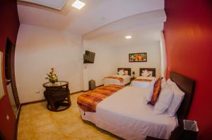 a hotel room with two beds and a television at Hotel Europa in Iquitos