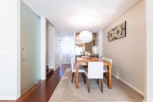 a dining room with a wooden table and white chairs at Front Beach Villa Cabedelo in Viana do Castelo +32 photos