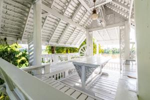a white pergola with a table on a porch at Hide & Seek River Villa in Ban Wang Wa (1)