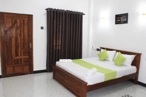 a bedroom with a bed and a wooden door at Royal Breeze Resort Sigiriya in Sigiriya