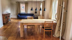a living room with a wooden table and chairs at Gemütliches Apartment im Grünen mit Kamin und Klöntür in Altenmedingen +2 photos