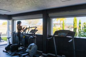 a woman standing in a gym with a simulator at Bella Vista Hôtel, Suites & Maisons in Porticcio