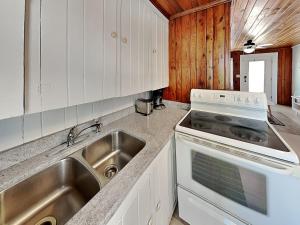 a kitchen with a sink and a stove at Sea Glass Suites 1 in Topsail Beach