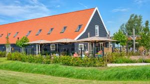 a building with an orange roof and a restaurant at Dutchen Erfgoedpark De Hoop Glamping, Appartementen & Cottages in Uitgeest