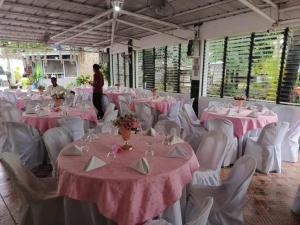 a room filled with tables and chairs with pink table cloth at GEN B Hotel in Buyu-an