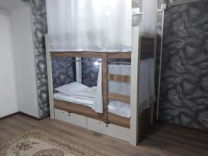 a small room with a bunk bed with a window at King Hostel in Old City in Baku