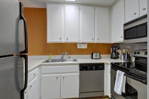 a kitchen with white cabinets and a sink at Biarritz Getaway - 1br condo downtown PS in Palm Springs