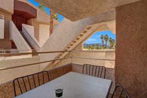 a table and chairs in a room with stairs at Biarritz Getaway - 1br condo downtown PS in Palm Springs