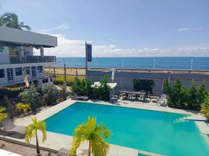 a pool in front of a building and the ocean at GEN B Hotel in Buyu-an