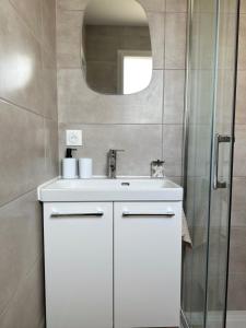 a bathroom with a white sink and a mirror at Entre Nantes et aéroport - Arrivée autonome 24h sur 24h in La Montagne +8 photos