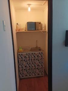 a bathroom with a sink and a microwave on a shelf at Estudios Tarem in Valparaíso