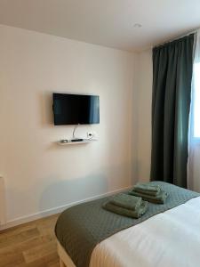 a bedroom with a bed with a flat screen tv on the wall at Entre Nantes et aéroport - Arrivée autonome 24h sur 24h in La Montagne